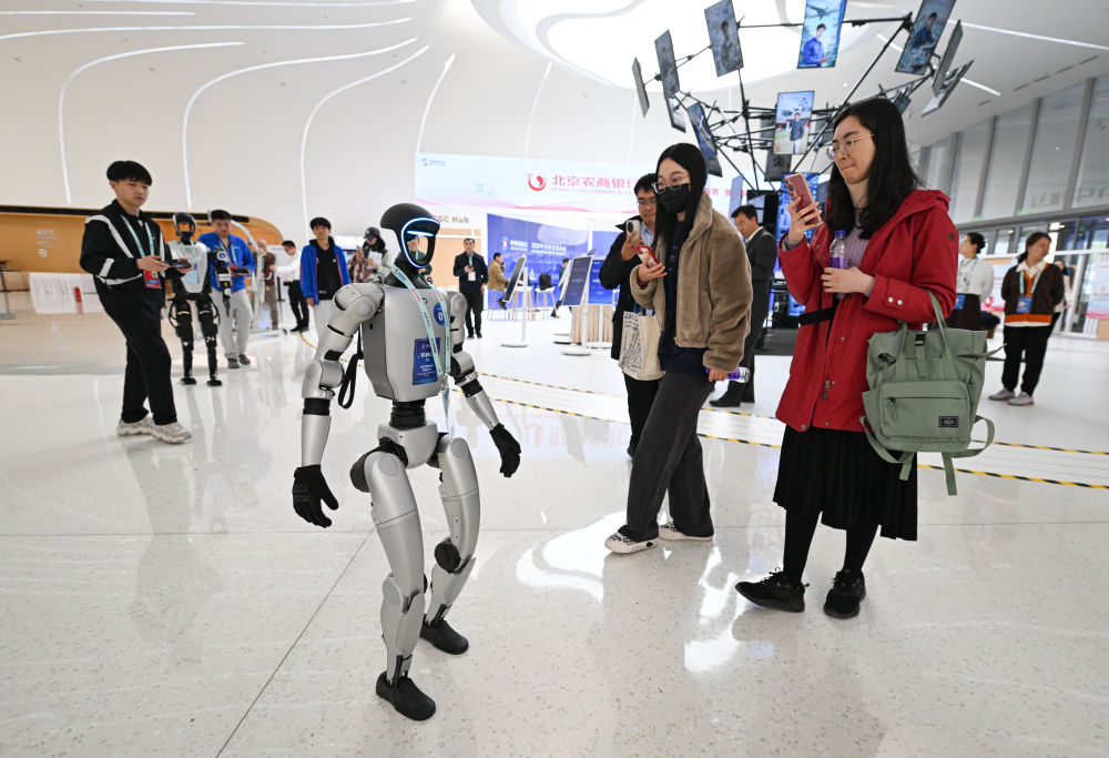 2025年3月26日,北京中关村国际创新中心的一款正在行走的宇树G1机器人吸引人们拍照留影。新华社记者 陈钟昊 摄.jpeg